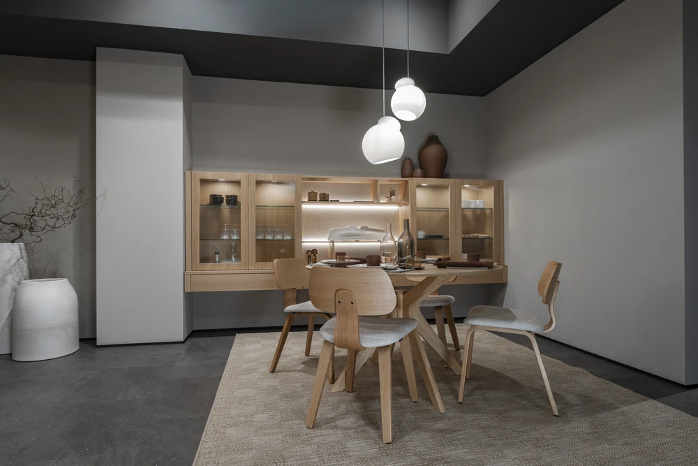 Cuisine moderne haut de gamme, plan de travail en marbre noir veiné or, crédence claire éclairée par spots encastrés sous meubles suspendus en chêne gris
