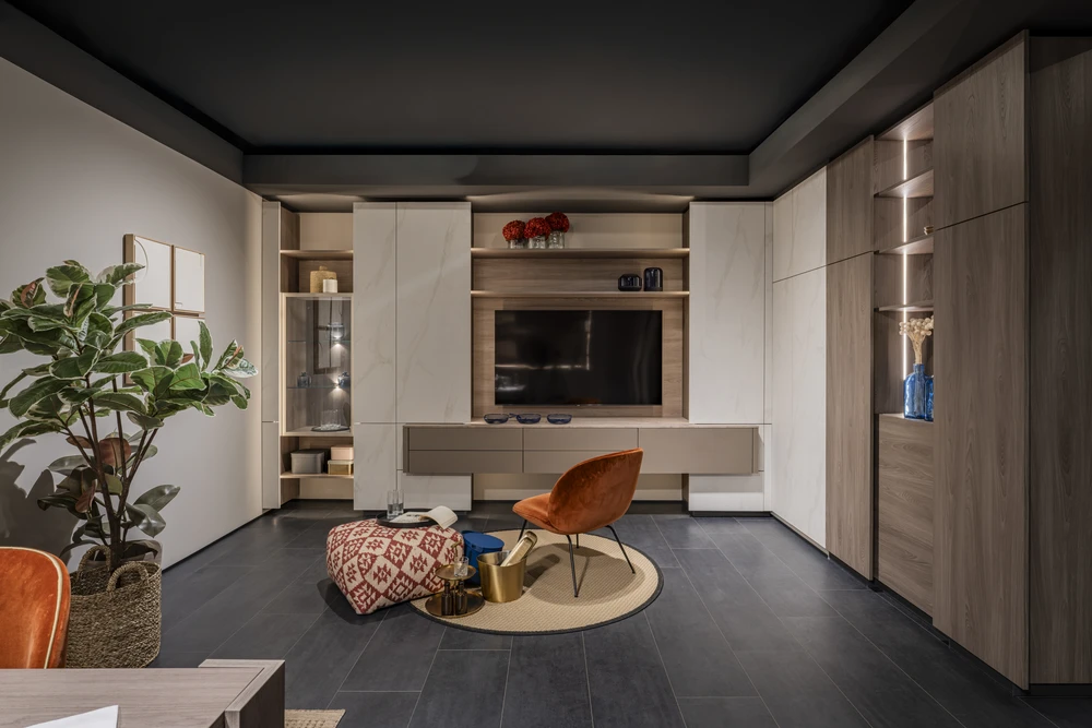 Salon moderne avec mur en pierre naturelle apparente, canapé d'angle en cuir blanc, table basse en verre et métal noir, tapis berbère